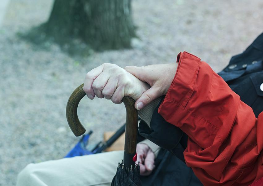 Hands of two women holding the handle of an umbrella